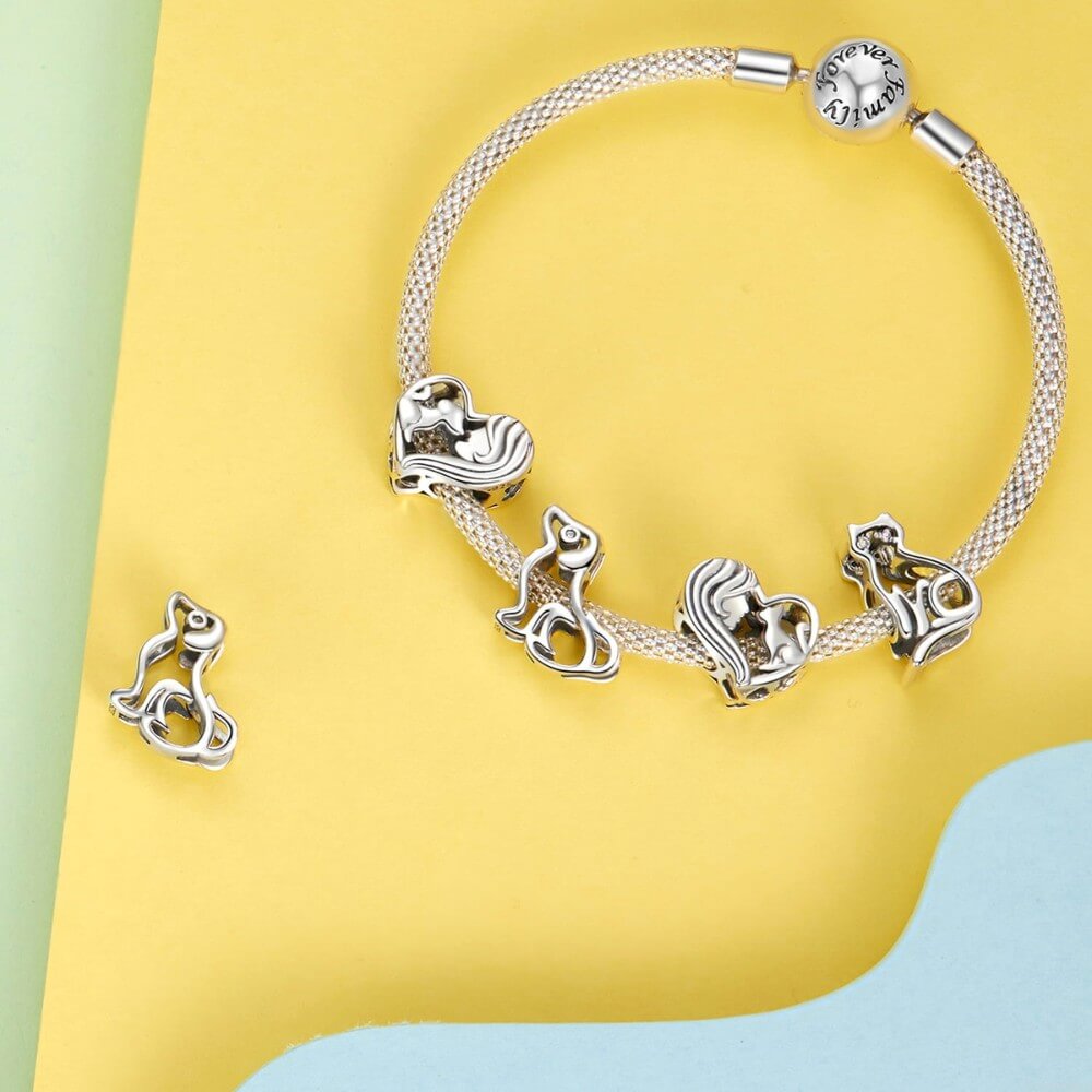 Sterling silver heart charm with woman and cat silhouette.