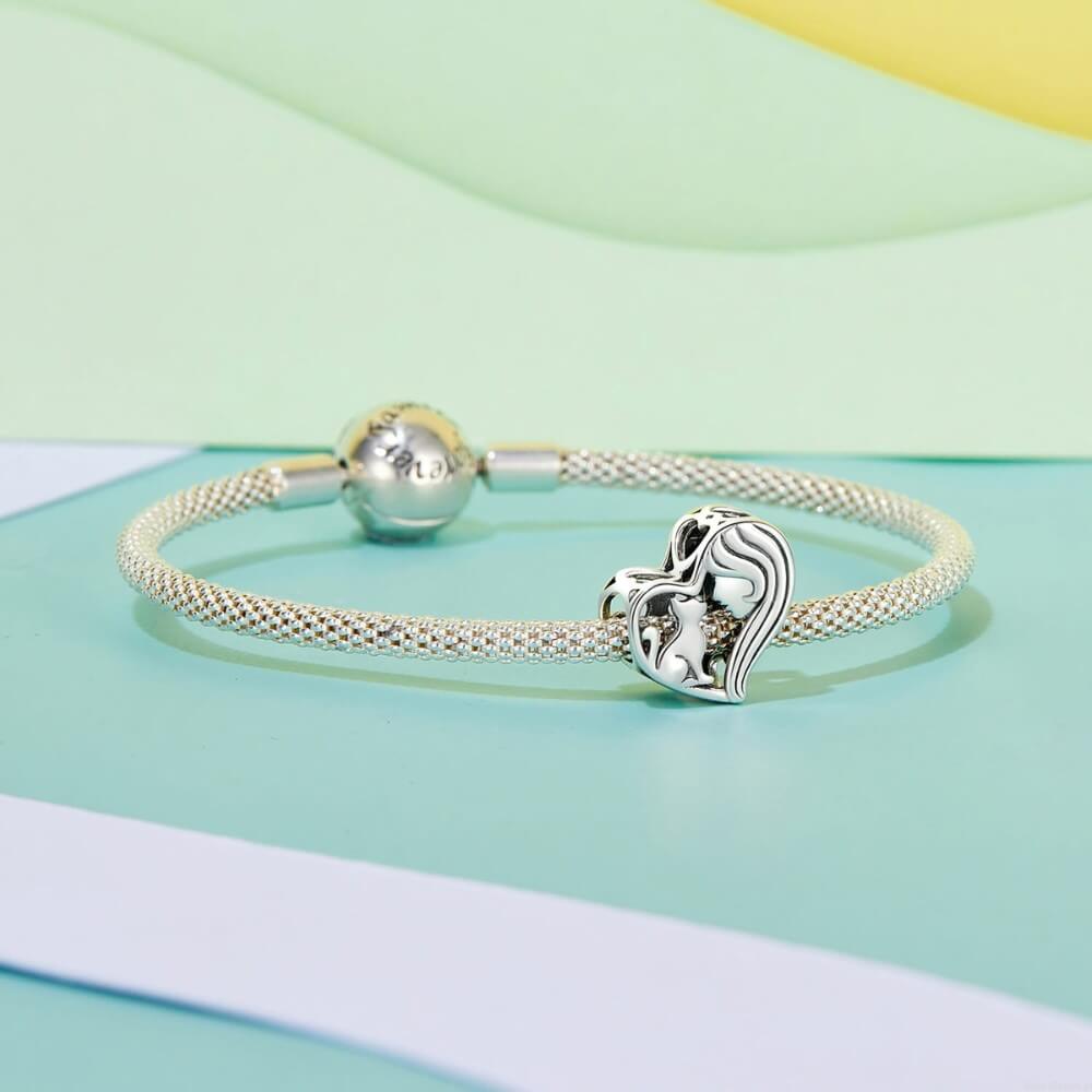 Sterling silver heart charm with woman and cat silhouette.