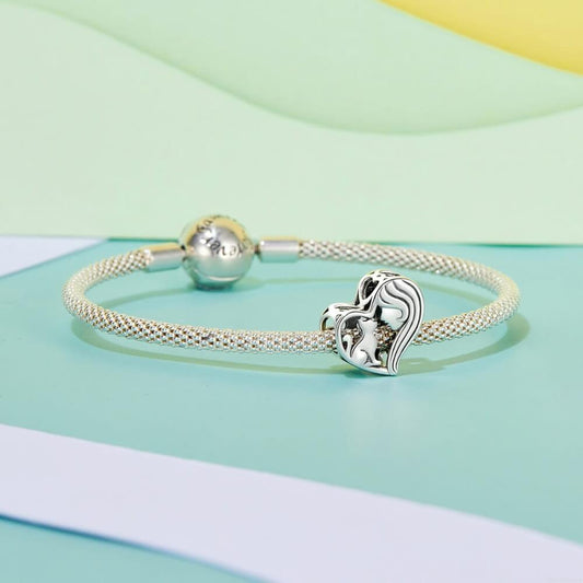 Sterling silver heart charm with woman and cat silhouette.
