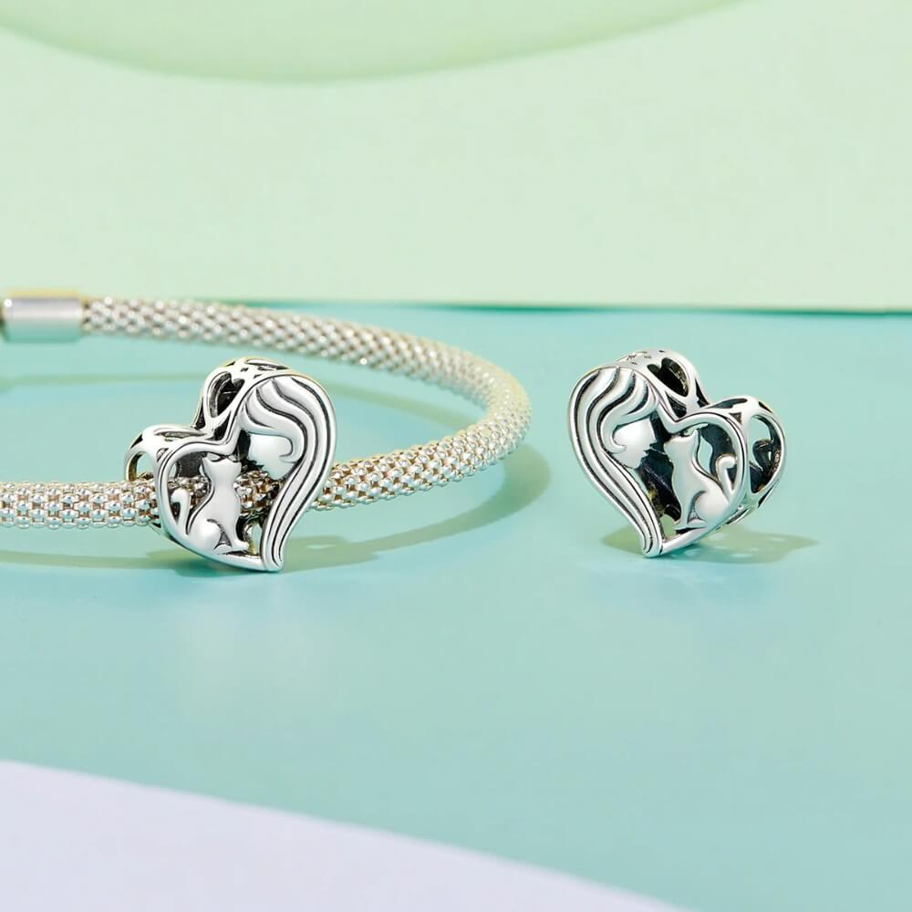 Sterling silver heart charm with woman and cat silhouette.
