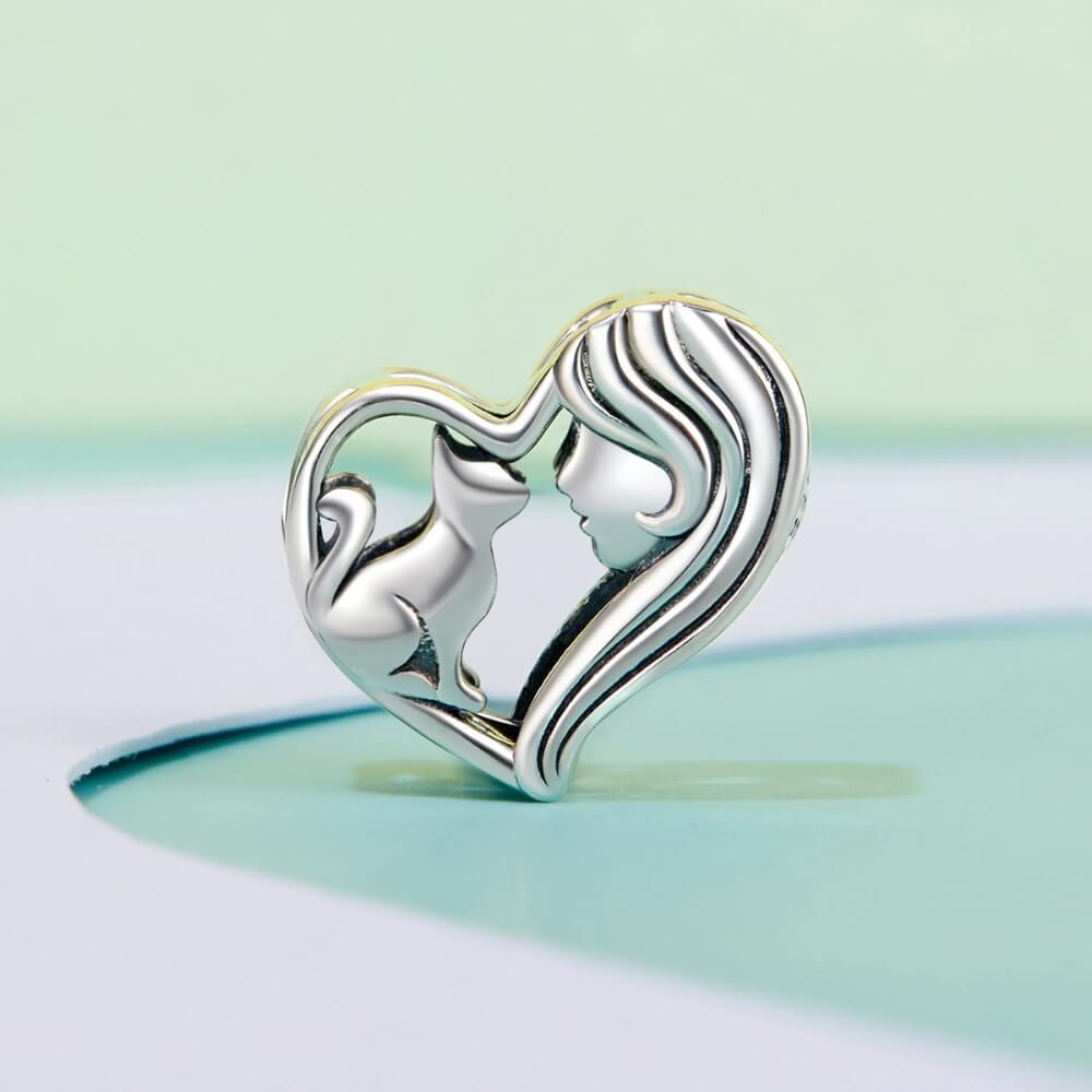 Sterling silver heart charm with woman and cat silhouette.